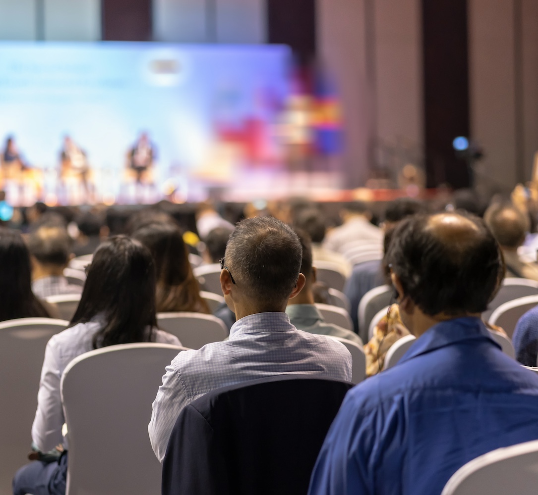 Rear view of Audience listening Speakers on the stage in the conference hall or seminar meeting, business and education about investment concept